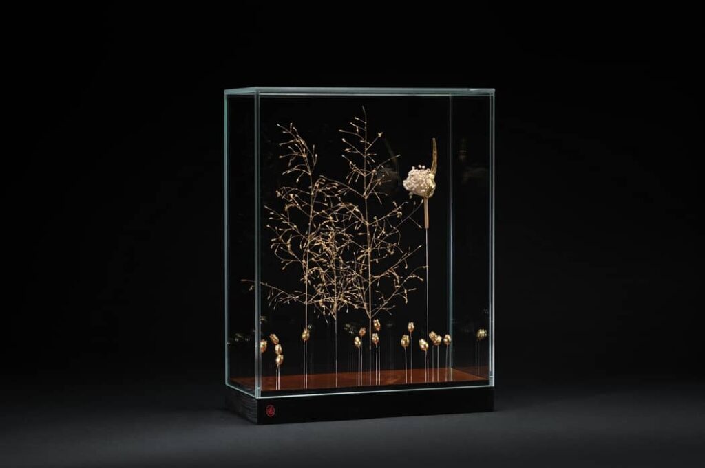 # Eclosion poétique : Placage d’acajou vernis tampon, tiges d’herbe d’amour (Eragrostis trichodes), silène (Silene vulgaris) etpoireau sauvage (Allium polyanthum) dorés à la feuille d’or.