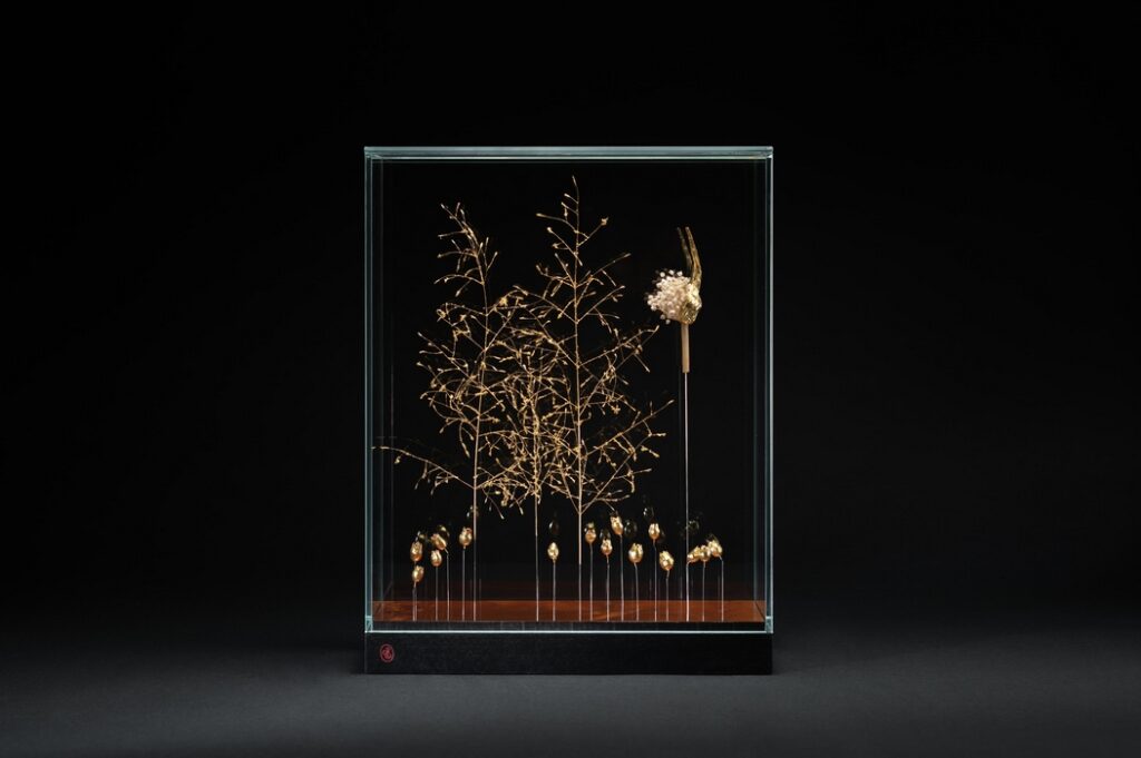# Eclosion poétique : Placage d’acajou vernis tampon, tiges d’herbe d’amour (Eragrostis trichodes), silène (Silene vulgaris) etpoireau sauvage (Allium polyanthum) dorés à la feuille d’or.